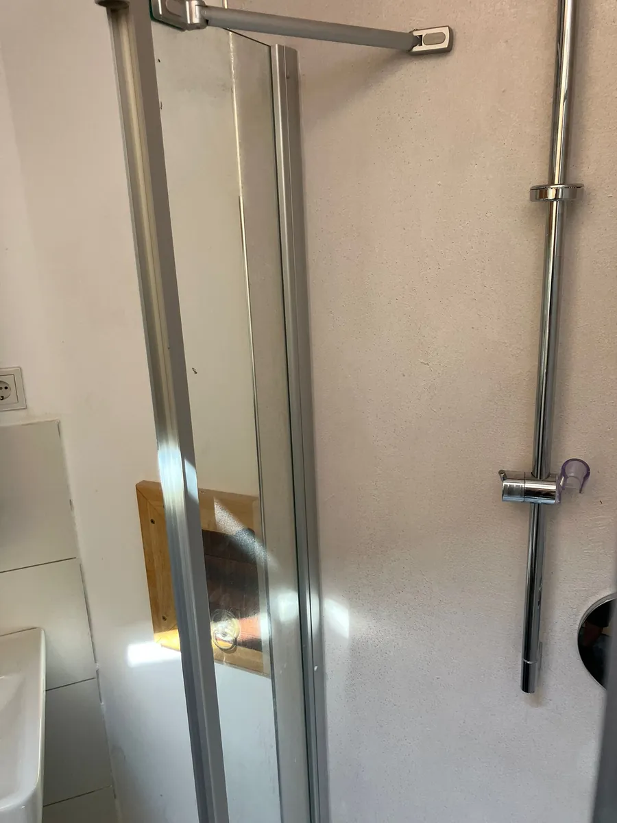 Sanierte Dusche mit neuer Wandverkleidung und Glaswand